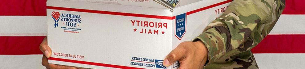 Man in military uniform holding an open package.